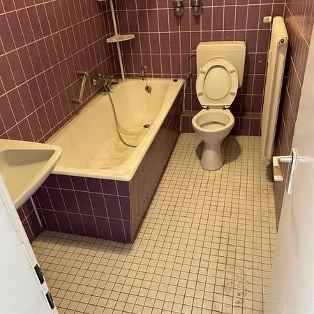 Altes Badezimmer mit Wanne und WC vor der Sanierung