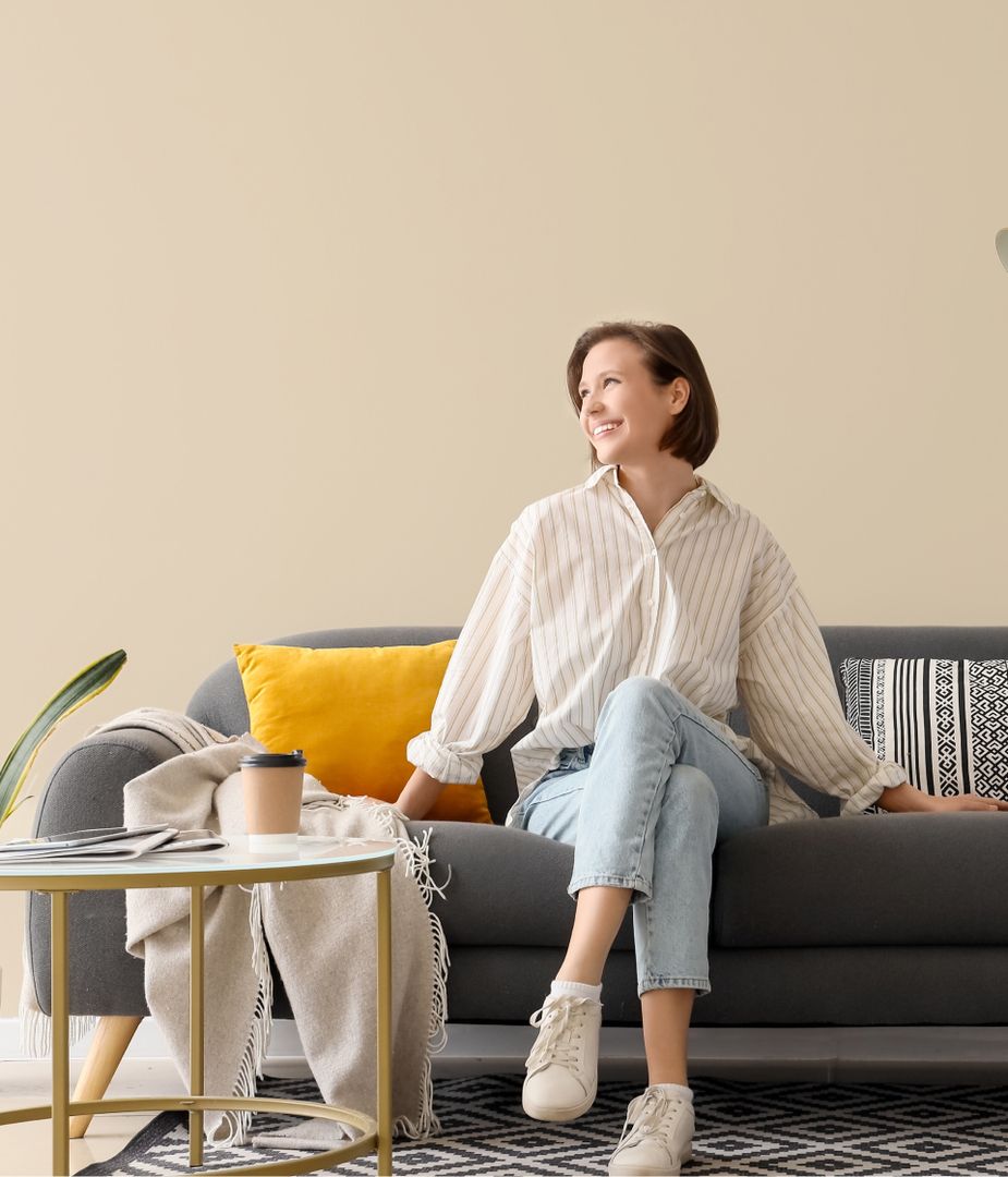 Zufriedene Kundin auf modernem Sofa nach erfolgreicher Renovierung durch VSV Renovierungen